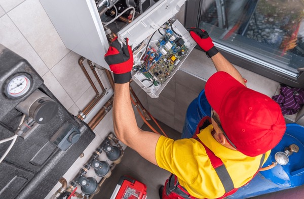 Technicien réparant une chaudière gaz Vaillant en panne